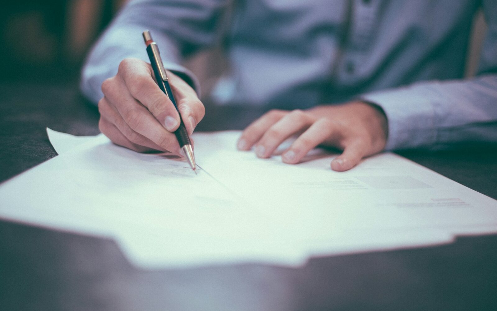 man writing on paper
